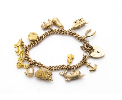 A vintage and modern 9ct gold charm bracelet, the curb link chain probably from a watch chain mounted with several 9ct gold c
