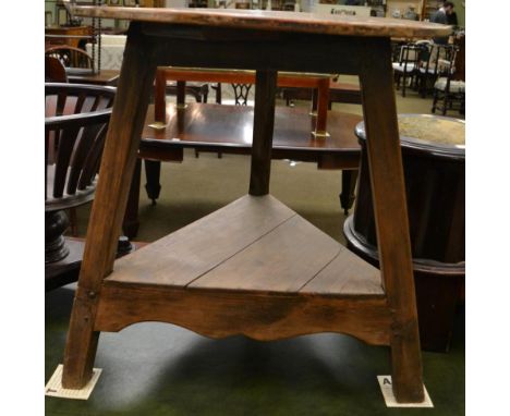 A 19th century pine cricket table with circular top and triangular shaped shelf 