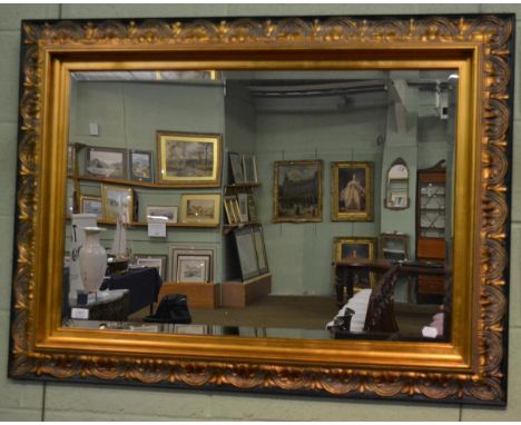 A reproduction gilt bevelled glass mirror, with rectangular plate and acanthus decorated frame, 115cm by 84cm