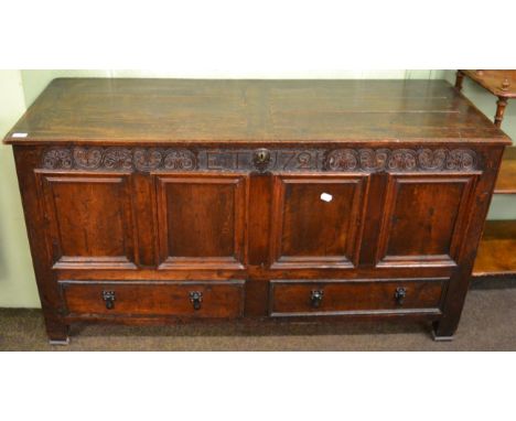 An 18th century oak four panelled coffer, fitted with two base drawers, containing a quantity of vintage hats