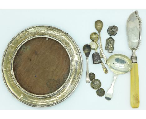 A silver caddy spoon, four silver salt spoons, a silver circular picture frame, a/f, a Victorian silver butter knife by Georg