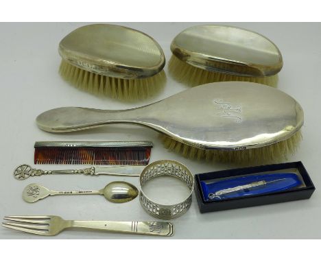 Nine silver items:- letter opener, fork, spoon, napkin ring, toothpick, three brushes and a comb