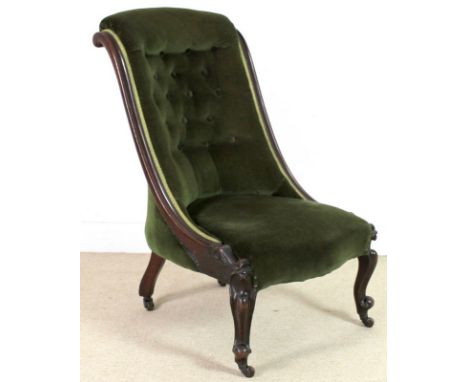 A Victorian mahogany nursing chair, with carved decoration, upholstered in green button back velvet, raised on short cabriole