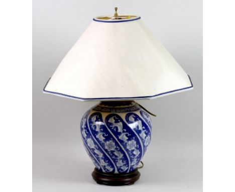 A modern Chinese porcelain blue and white table lamp, of ovoid form, with twin sockets, cream shade with hexagonal edge trimm