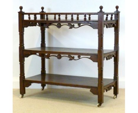 A Victorian oak buffet with three shelves, open gallery with turned spindles and finials to the corners, pierced and carved f
