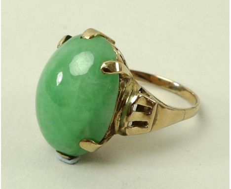 A Chinese/Hong Kong yellow metal and green jade ring, the central oval stone in claw setting with pierced shoulders, Chinese 