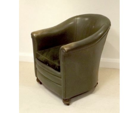 A club / office armchair, circa 1960, with green leather upholstery, raised on bun feet and ceramic castors.