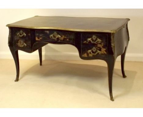 A 20th century French bureau plat, circa 1930, of gentle bombe form, cast brass fittings and green tooled leather surface, on
