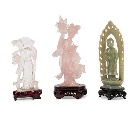 Two carved in the shape of female figures in crystal rock and pink quartz, one a jade Buddha, all resting on their wooden sta