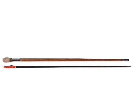 Two walking sticks, including a stick with silver and stone ball handle, and a stick with an 18k gold and coral Guanyin on th