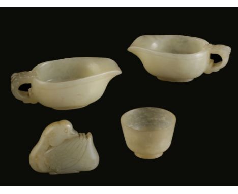 TWO MING STYLE CELADON JADE LIBATION CUPS, EARLY 20TH CENTURY, with dragon mask carved scroll handles, 11.5cm long; together 