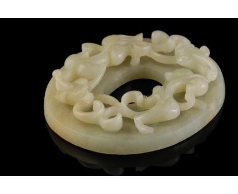 CARVED WHITE JADE PLAQUE, the oval plaque carved in high relief with two entwined chilongs, 10cm wide; together with another 