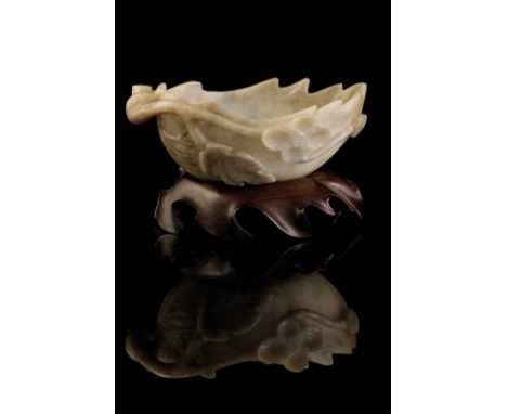 SMALL CARVED GREY AND WHITE JADE 'PEACH' FORM CUP, LATE QING / EARLY REPUBLIC, on a wood stand, 9cm long