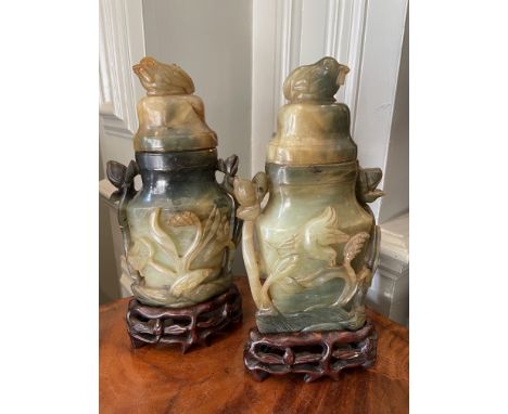 Property of a GentlemanPair of jade urns With floral design and bird topped lidsOn carved wooden standsDimensions:9 in. (H) x