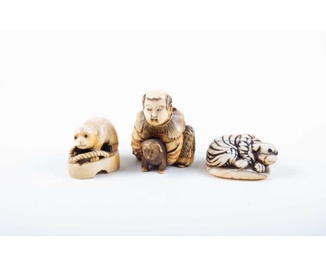 A Japanese ivory okimono and two netsukes, Meiji, the okimono carved as a wealthy young boy dressed in ornate robes, kneeling