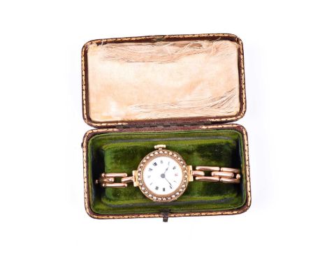 An early 20th century yellow metal ladies wristwatch, with white enamel Roman numeral dial, the bezel inset with split seed p