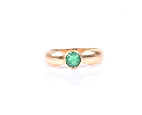 An 18ct yellow gold and emerald ring, bezel set with a round-cut emerald, approximately 4.5 mm diameter, the shank marked 18k