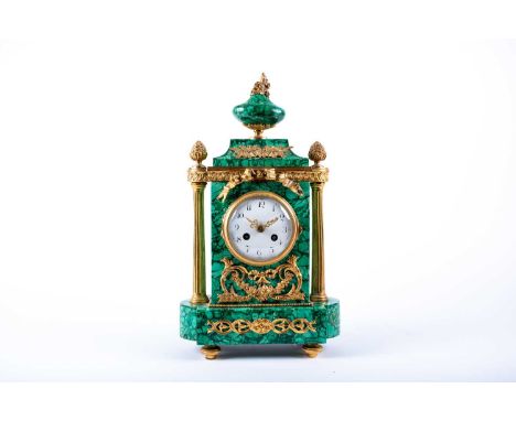 A French Empire style malachite and ormolu mounted mantle clock, with white circular enamel dial with painted arabic numerial