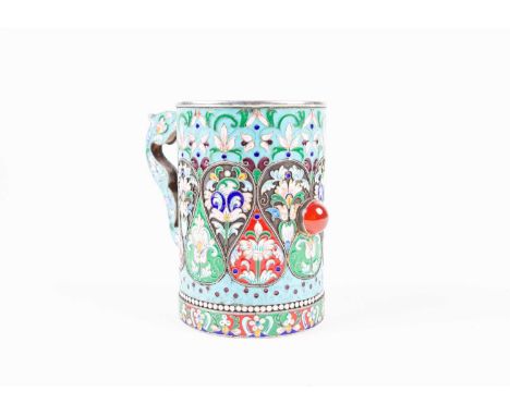 A Russian silver gilt and enamel scroll-handled tankard, with inset cabachon stone and vivid foliate decoration, impressed ma