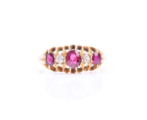 A late 19th / early 20th century yellow metal, diamond, and ruby ring, set with two old-cut diamonds and three mixed-cut rubi