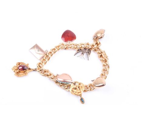An 18ct yellow gold curb-link charm bracelet, with smooth and decorated links, suspended with eight charms, including a gold 