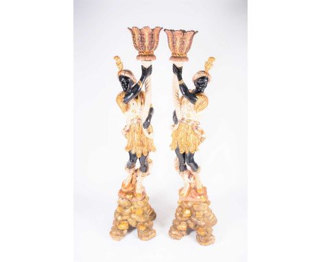 A pair of large 20th century blackamoors, wood carved with bright polychrome decoration, each holding aloft a planter, standi