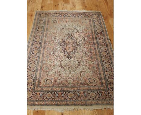 A cream ground silk Kashmiri carpet, floral design within indigo border, 215 x 130cm