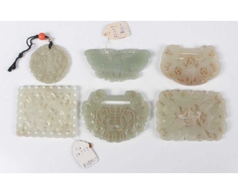A group of six Chinese pale celadon jade pendants, probably 20th century, all carved and pierced, including two lock pendants