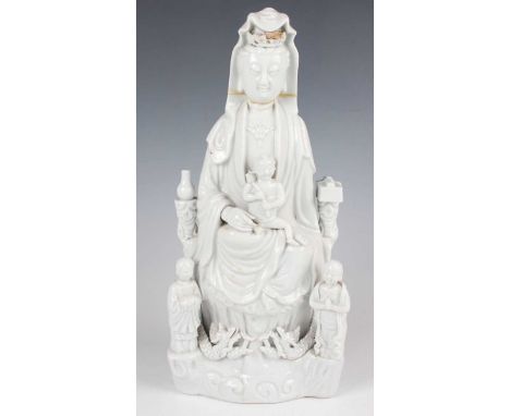 A Chinese blanc-de-Chine porcelain figure group of Guanyin and her attendants, probably Kangxi period, the seated bodhisattva