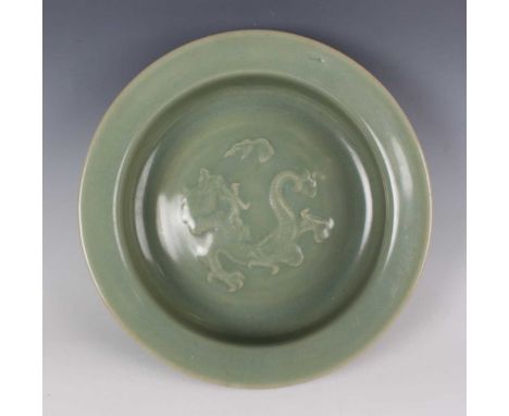 A Chinese Longquan celadon glazed porcelain basin, Ming dynasty, the interior decorated in low relief with a dragon and vapou