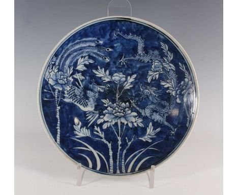 A Chinese blue and white porcelain circular dish, mark of Kangxi but late 19th century, painted with a confronted fenghuang a