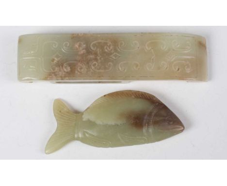 A Chinese pale celadon jade buckle, probably Ming dynasty, of curved rectangular form, the front finely carved in low relief 