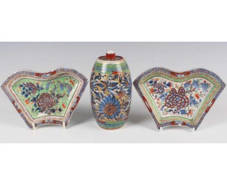 A Chinese 'clobbered' blue and white porcelain spirit bottle, Kangxi period and later, of barrel form, painted in underglaze 