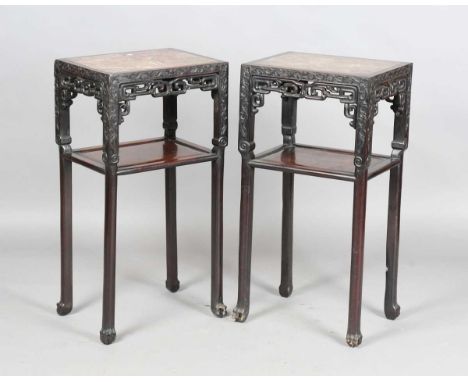 A pair of Chinese hardwood rectangular two-tier stands, late 19th century, each inset with a rouge marble panel above a carve