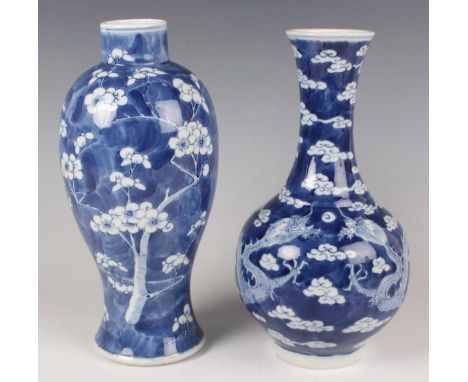 A Chinese blue and white porcelain bottle vase, mark of Kangxi but late 19th century, painted with dragons and vapours, under