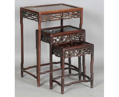 A Chinese hardwood rectangular occasional table, late 19th century, the panelled top above a carved and pierced scroll apron,