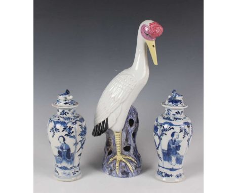 A pair of Chinese blue and white porcelain vases and covers, mark of Kangxi but late 19th century, each baluster body painted