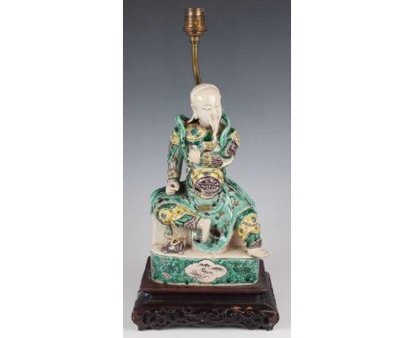 A Chinese famille verte enamelled porcelain figure of Guandi, late 19th/early 20th century, modelled seated wearing armour an