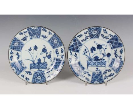 A pair of Chinese blue and white export porcelain circular plates, Kangxi period, painted with flowers and fence within a seg