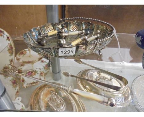 A silver plate basket, toasting fork, sugar tongs and two pairs of knife rests.