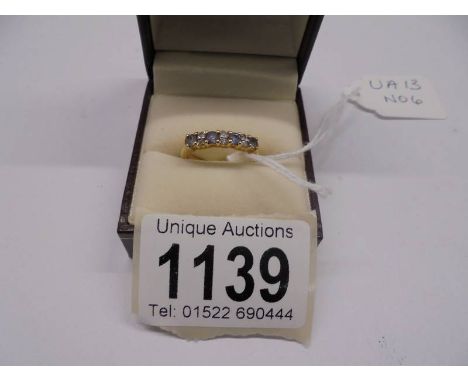 A diamond and tanzanite ring, 4 tansanites, 6 diamonds dated Birmingham 2005 in 18ct gold. Size K half.