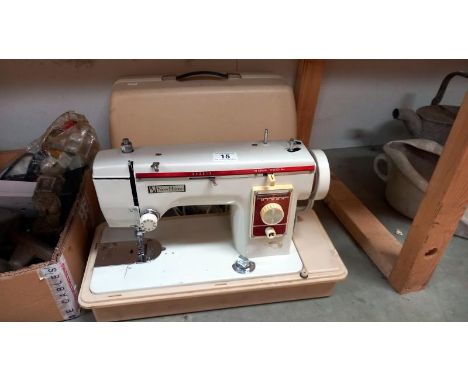 A cased New Home sewing machine. COLLECT ONLYNot PAT tested.Plugged in, the light came on & needle went up & down when pedal 