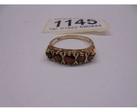 A ring set with five garnets in a graduated design, dated London 1981 in 9ct gold.