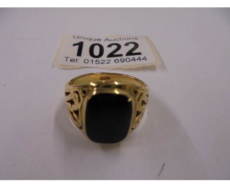 A yellow metal ring set black onyx, size R half. 68gms