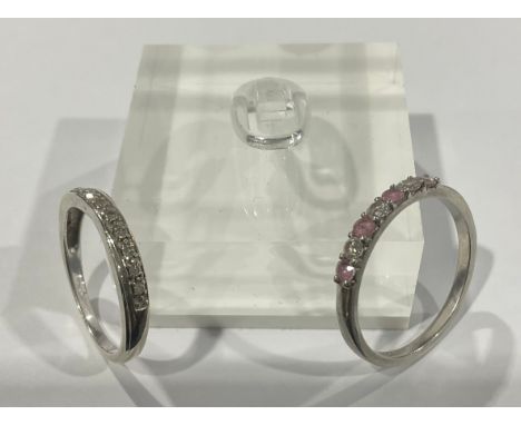 A platinum engagement ring, set with three brilliant cut diamonds, interspersed with pink stones, size R/S, marked 950, 3.5g;