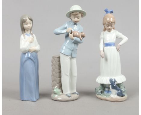 Three Nao porcelain figures one of a boy in hat holding a puppy, one of a girl with a puppy at her feet, the other of a girl 