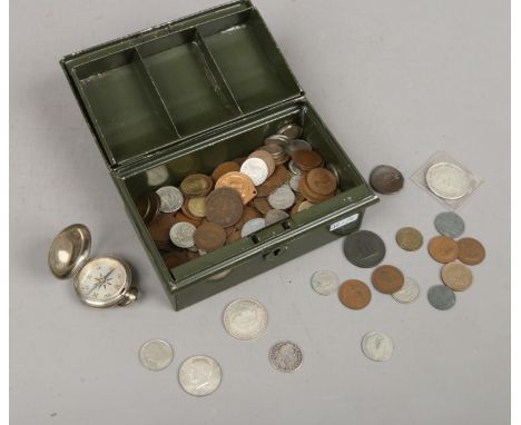 A tin of assorted coins including a George III silver shilling and a brass compass.