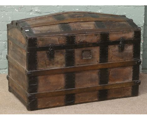 A metal bound dome top travel trunk with fitted interior.