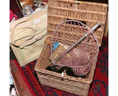 A vintage fishing basket and contents landing net, green glass floats, reel and a alluminium lined canvas satchel.