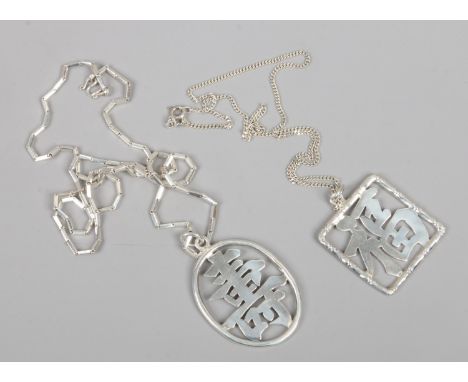 Two silver pendants and silver chains both pendants decorated with Chinese characters.